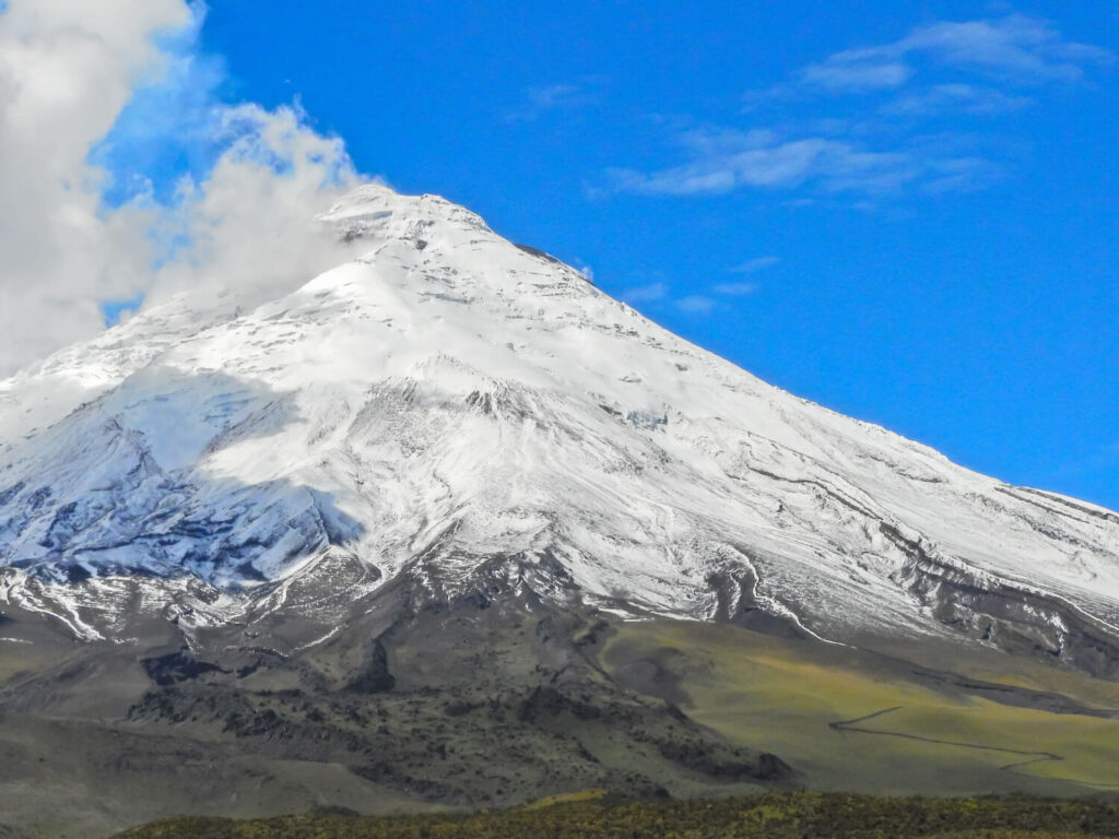 Snow-capped Cotopaxi volcano under a blue sky, Ecuador